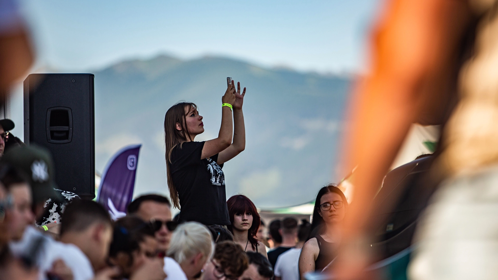 Dievča fotí koncert vysoko nad ľuďmi